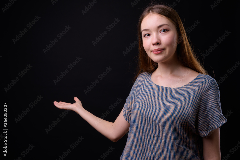 Young beautiful woman with long brown hair against black background Young beautiful woman with long brown hair against black background