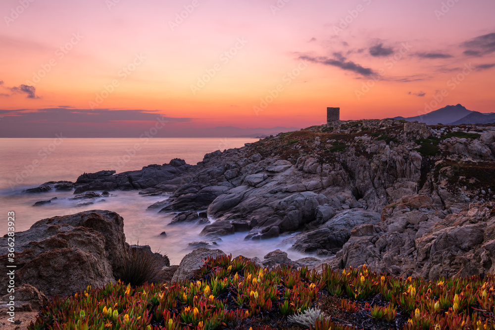 Dawn breaking behind genoese tower in Corsica