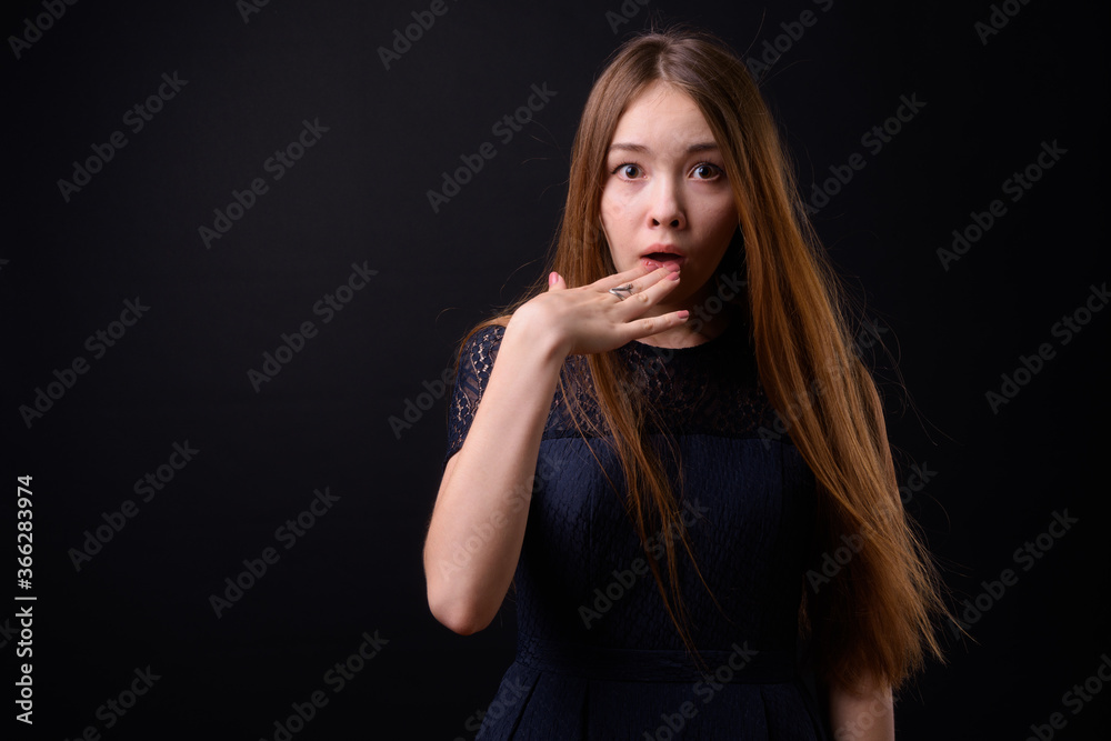 Young beautiful woman with long brown hair against black background Young beautiful woman with long brown hair against black background