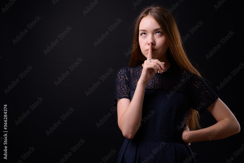 Young beautiful woman with long brown hair against black background Young beautiful woman with long brown hair against black background