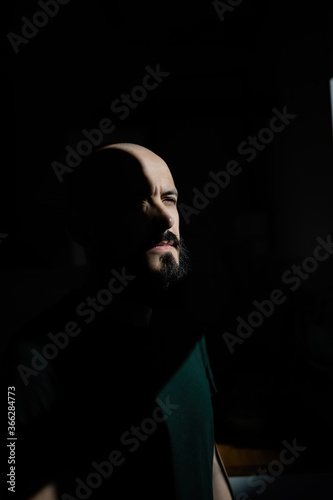 Abstract portrait of a man with a beard in the sun. Minimalism of the forms of light and shadow.