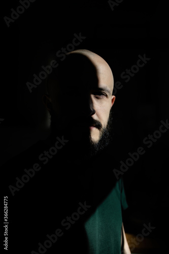 Abstract portrait of a man with a beard in the sun. Minimalism of the forms of light and shadow.