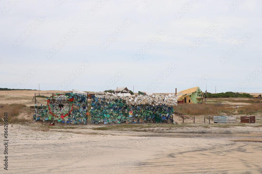 Wall built with plastic pieces returned by the tide