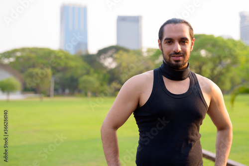 Young handsome bearded Indian man at the park