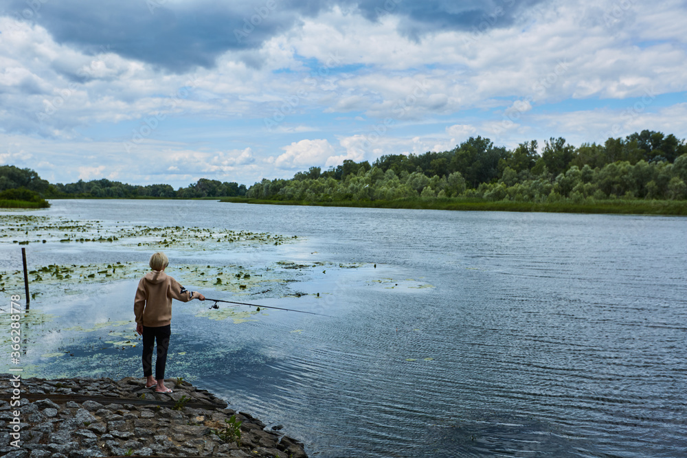 Young lady fishing perch on the river