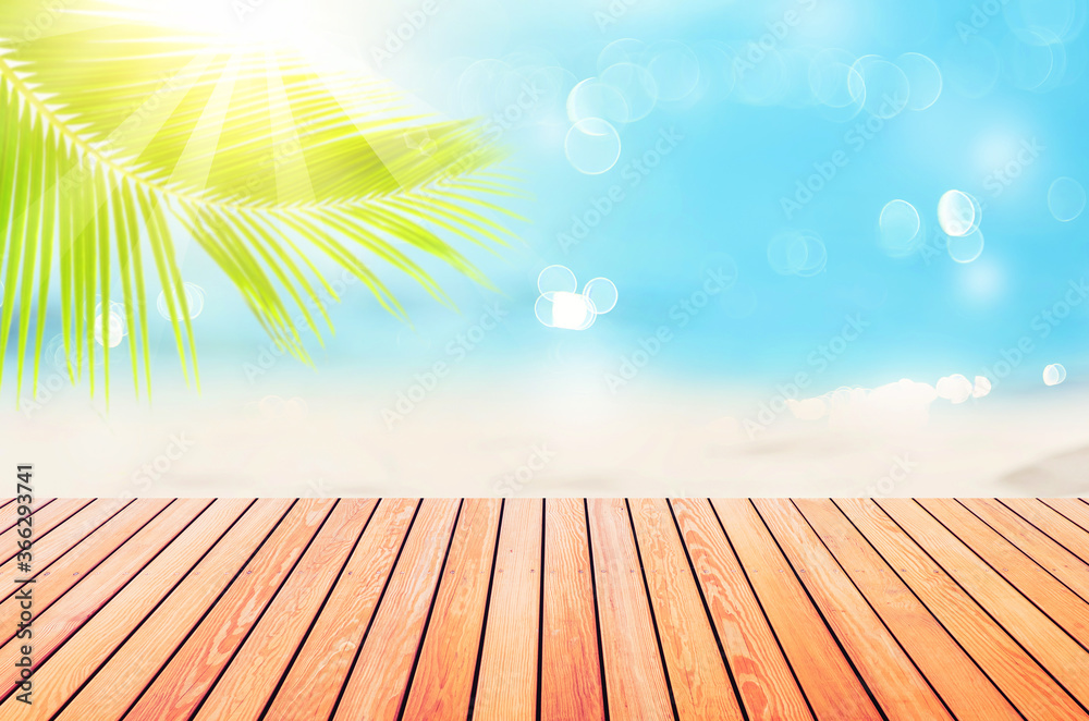 Blur tropical beach with bokeh sun light wave and palm tree on empty old wood table abstract background. Blur tropical beach with bokeh sun light wave and palm tree on empty old wood table abstract background.