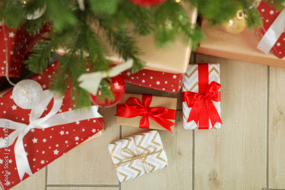 Many gifts under a festively decorated Christmas tree in a bright interior
Many gifts under a festively decorated Christmas tree in a bright interior