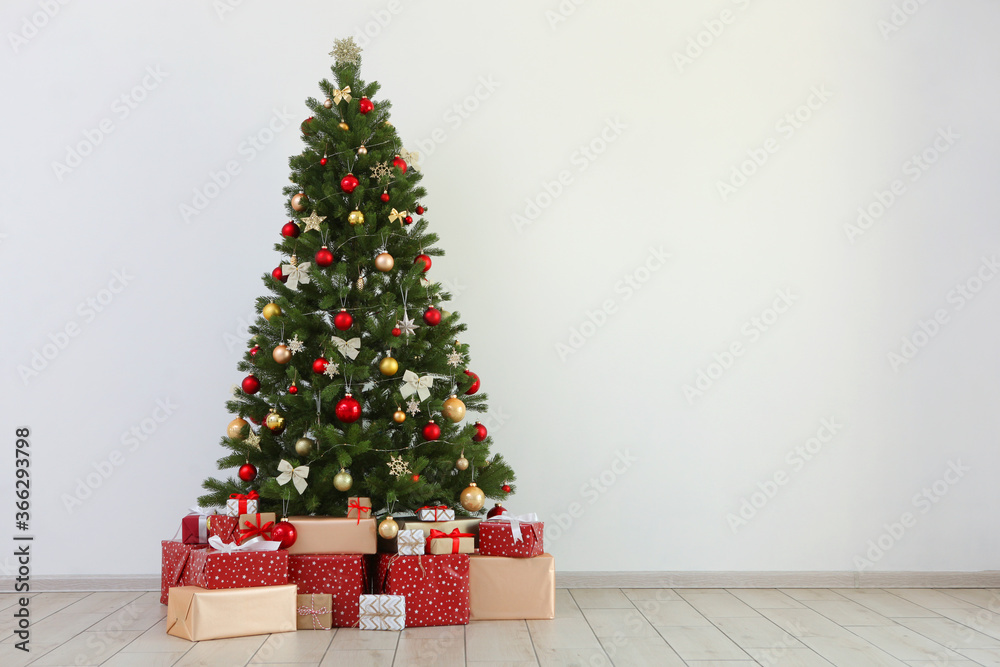 Many gifts under a festively decorated Christmas tree in a bright interior
Many gifts under a festively decorated Christmas tree in a bright interior