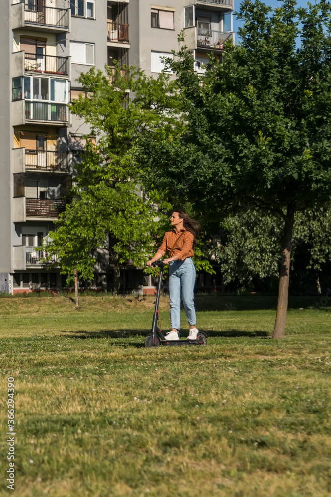 A young woman is driving on an electric scooter A young woman is driving on an electric scooter