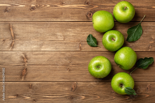 Fresh green apples on rustic wooden background