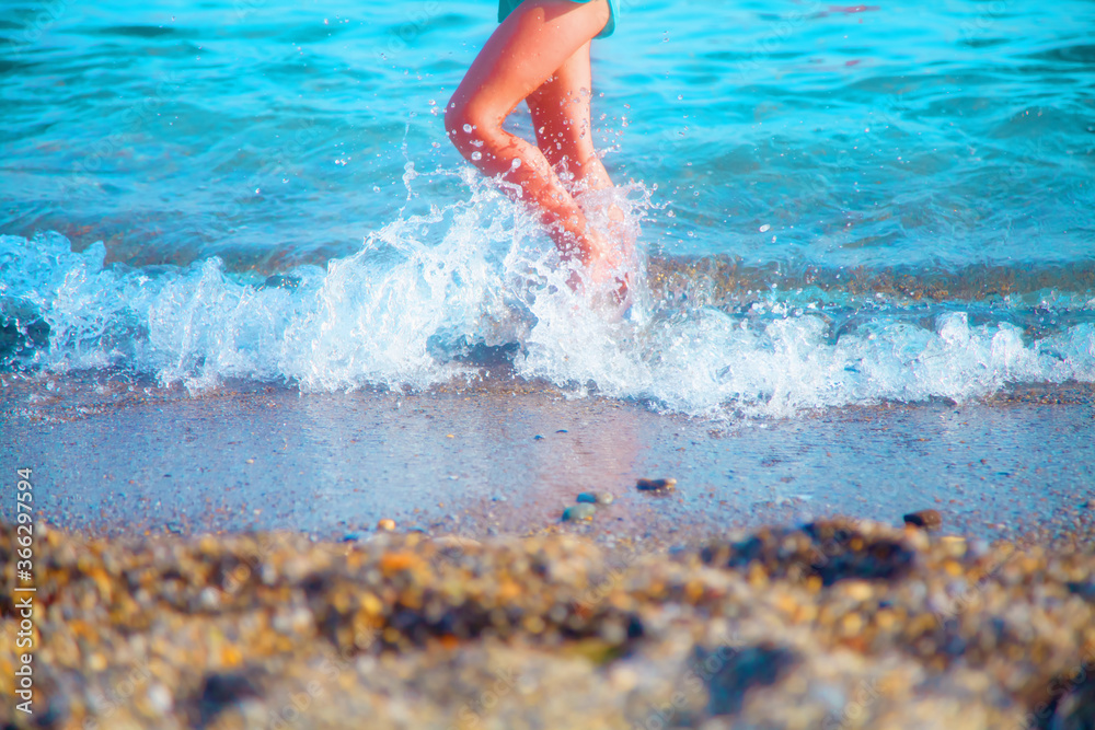 Summer holiday and leisure concept. Cute young child girl walking in sea water.