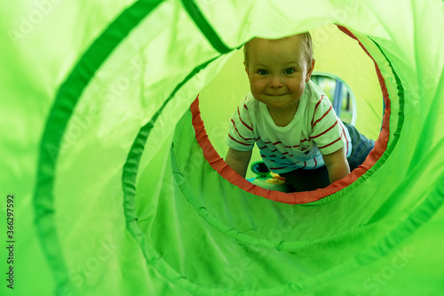 1-2 years old child boy playing  in a tunnel tube.