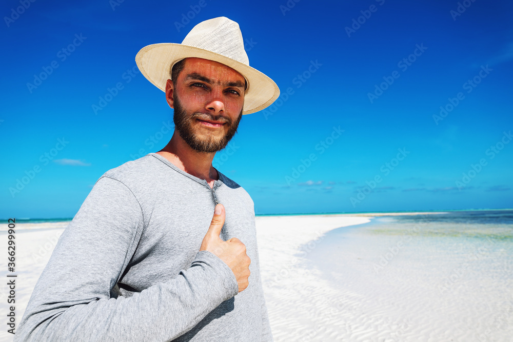Portrait of man in white hat on sand bank