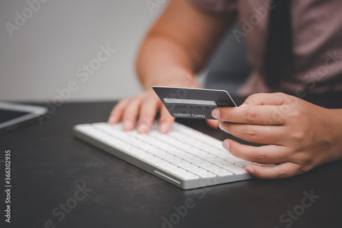 Woman is using a hand typing keyboard and uses a modern credit card by laptop or smartphone.shopping online on the card and buy order shopping online.