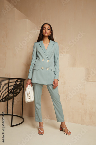 Beautiful brunette woman natural make up wear fashion clothes casual dress code office style blue jacket and pants suit for romantic date business meeting accessory bag interior boho stairs .