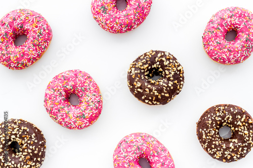 Donuts flat lay pattern on white background, top view
