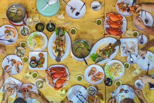 Top view of Happiness family enjoy eating with a variety of seafood dishes on dinner.