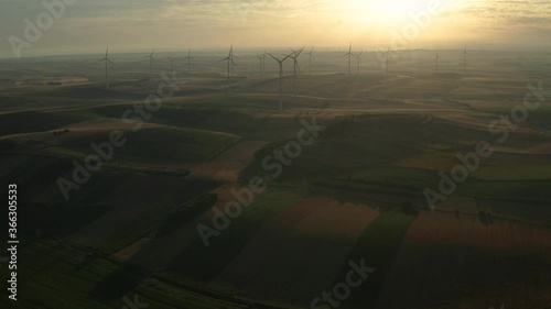 Aerial view of Wind turbines of save Energy save world in video 4k format. aerial shot on sunset. drone footage wind turbines at sunrise with beautiful clouds. Global warming concept and green energy.