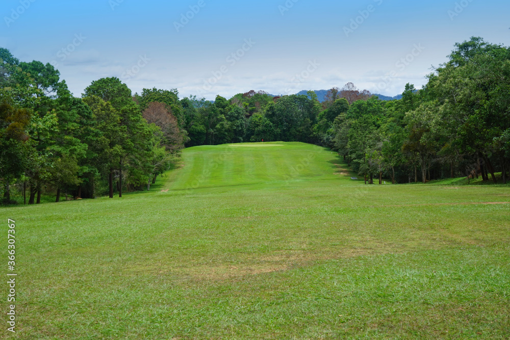 Background of evening golf course has sunlight shining down at golf course in Thailand. Nice scenery on a golf course at a late summer afternoon