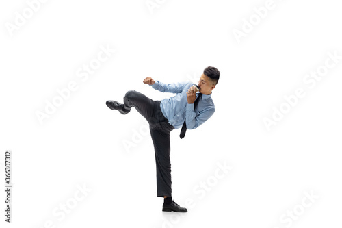 Strong. Man in office clothes practicing taekwondo on white background like professional player, sportsman. Unusual look for businessman in motion, action with ball. Sport, healthy lifestyle © master1305