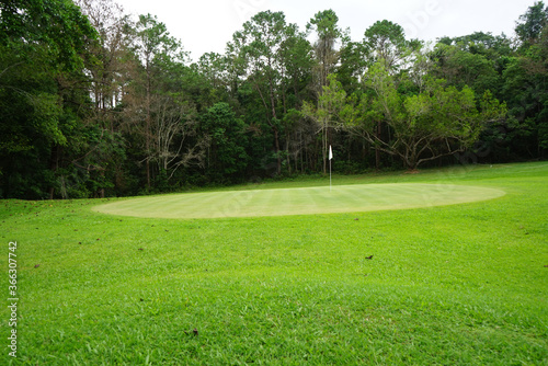 Background of evening golf course has sunlight shining down at golf course in Thailand. Nice scenery on a golf course at a late summer afternoon