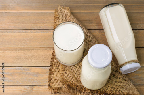 Rustic milk bottles and milk glasses placed on a wooden table Organic milk products that are nutritious and healthy Top view