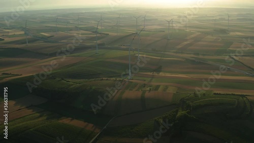 Aerial view of Wind Turbines Farm and Agricultural Fields. Austria. Farmlands and the Wind Turbines Power Plant. Flying by Drone near Wind Power, Turbine, Windmill. Energy Production. Clean and
