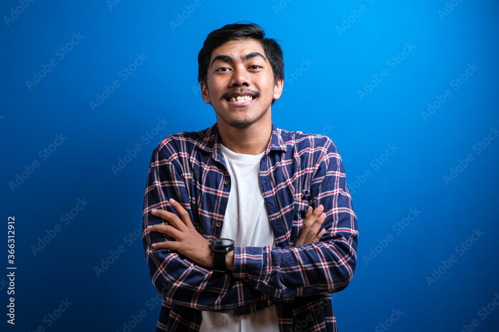 Asian young students smiled at the camera looking confident while putting both hands on the chest against blue background. Studio shots Asian young students smiled at the camera looking confident while putting both hands on the chest against blue background. Studio shots