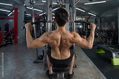 Sporty man training doing exercise in fitness gym