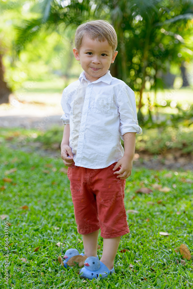 Young adorable little boy with blond hair at the park outdoors Young adorable little boy with blond hair at the park outdoors