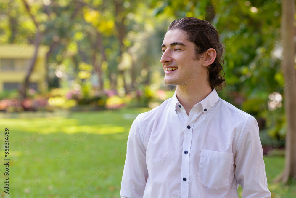 Happy young handsome businessman thinking at the park outdoors Happy young handsome businessman thinking at the park outdoors