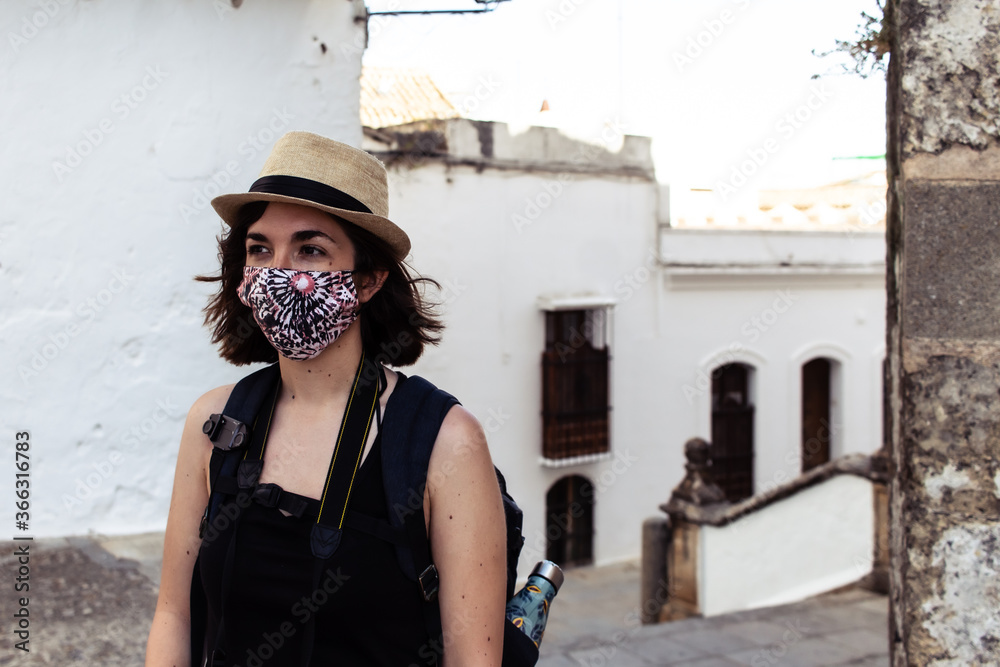 Attractive young female visiting an old town while wearing a facemask during coronavirus pandemic Attractive young female visiting an old town while wearing a facemask during coronavirus pandemic