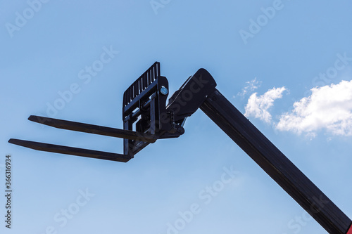 pitchfork manipulator in the background of clouds performing loading works