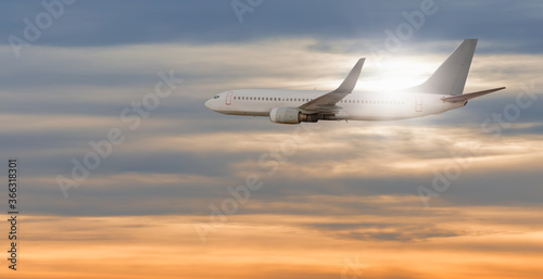 White passenger airplane in the sunset clouds  - Travel by air transport