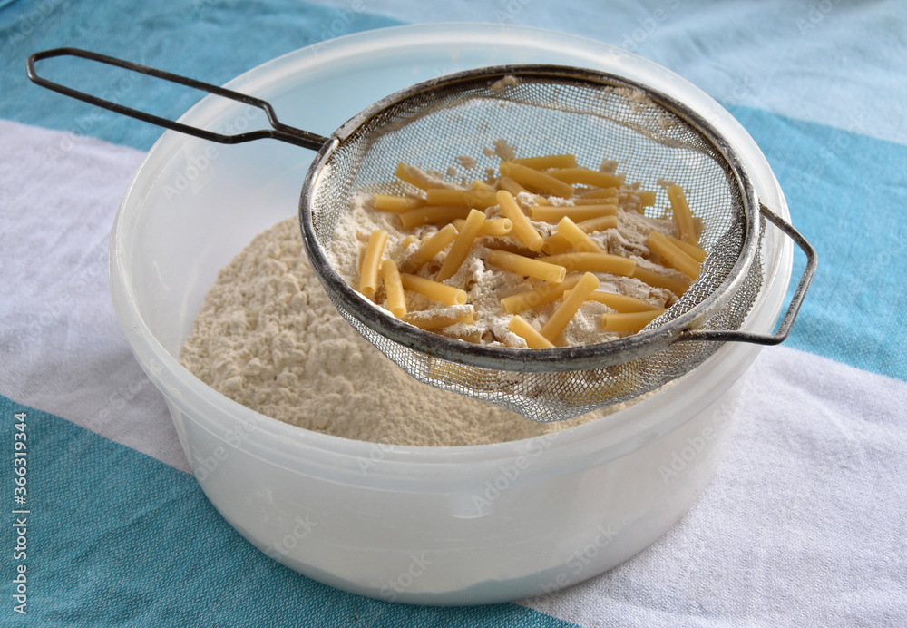 Sieve full of pasta with flour going through Sieve full of pasta with flour going through