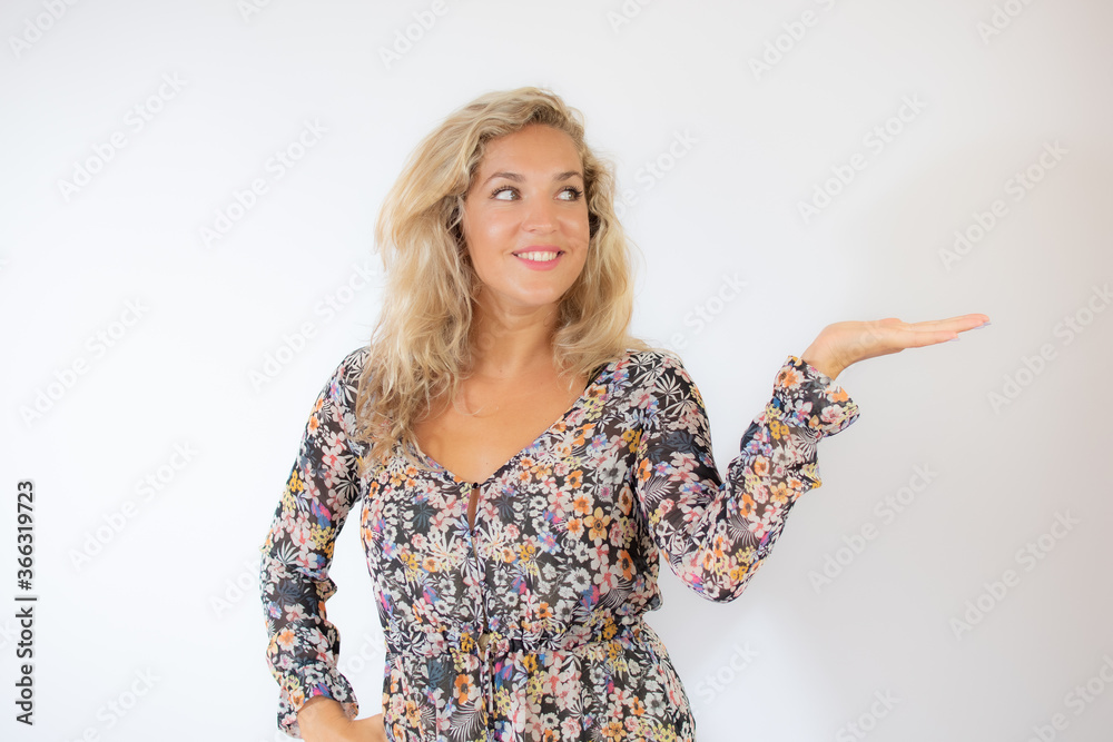 Pretty blonde woman in a flowery dress gesturing on white background Pretty blonde woman in a flowery dress gesturing on white background
