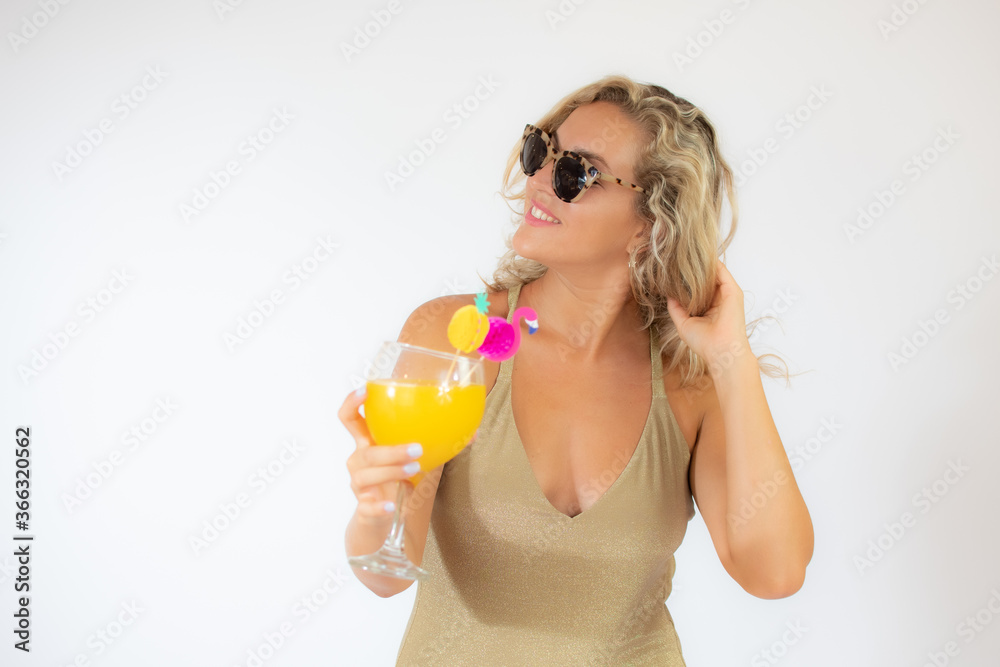 Pretty smiling blonde woman with sunglasses in golden swimsuit with a fruit cocktail Pretty smiling blonde woman with sunglasses in golden swimsuit with a fruit cocktail