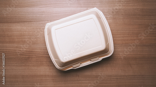 take-away box or take-out foam container from food delivery service on wooden table
