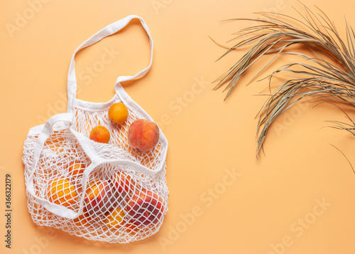 Summer composition. Peaches and dry palm leaves on orange background. Copy space. Top view