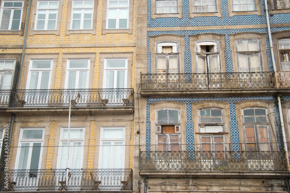 Close detail of an old and vintage facade of Portuguese residential building with colorful tile wall and large windows with balconies in Porto Portugal Europe