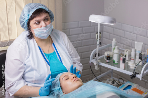 A young girl is cleaning the skin of her face at a cosmetologist. Facial cleansing and massage