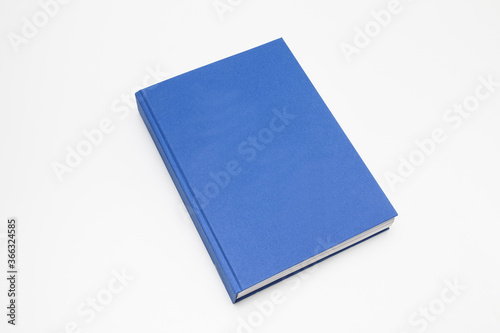 Blue book with no title standing on white background
