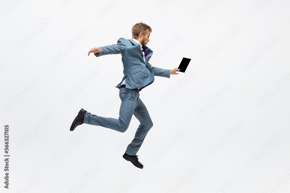 Winner, jump. Man in office clothes running, jogging on white background like professional athlete, sportsman. Unusual look for businessman in motion, action with ball. Sport, healthy lifestyle Winner, jump. Man in office clothes running, jogging on white background like professional athlete, sportsman. Unusual look for businessman in motion, action with ball. Sport, healthy lifestyle