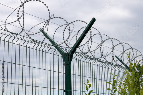 An iron fence with barbed wire encloses the restricted area.