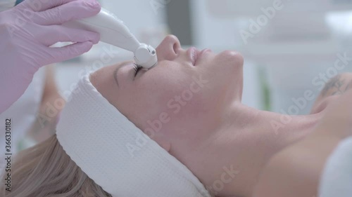 Professional cosmetologist woman doing hydrogen face purification