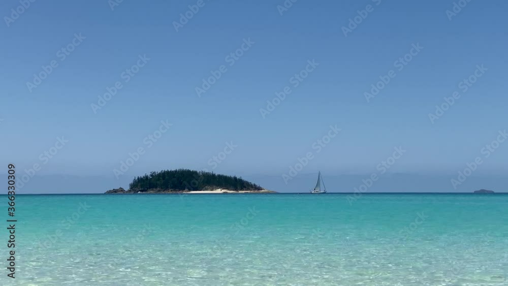 Islet in front of Whitehaven beach with sailing boat Islet in front of Whitehaven beach with sailing boat