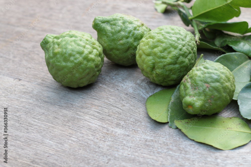 Obraz premium Group of fresh Bergamot fruit and bergamot leaves on wooden table background