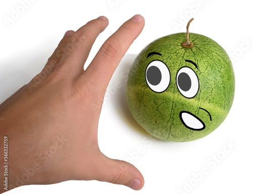 hand reaches for the fruit with a frightened face