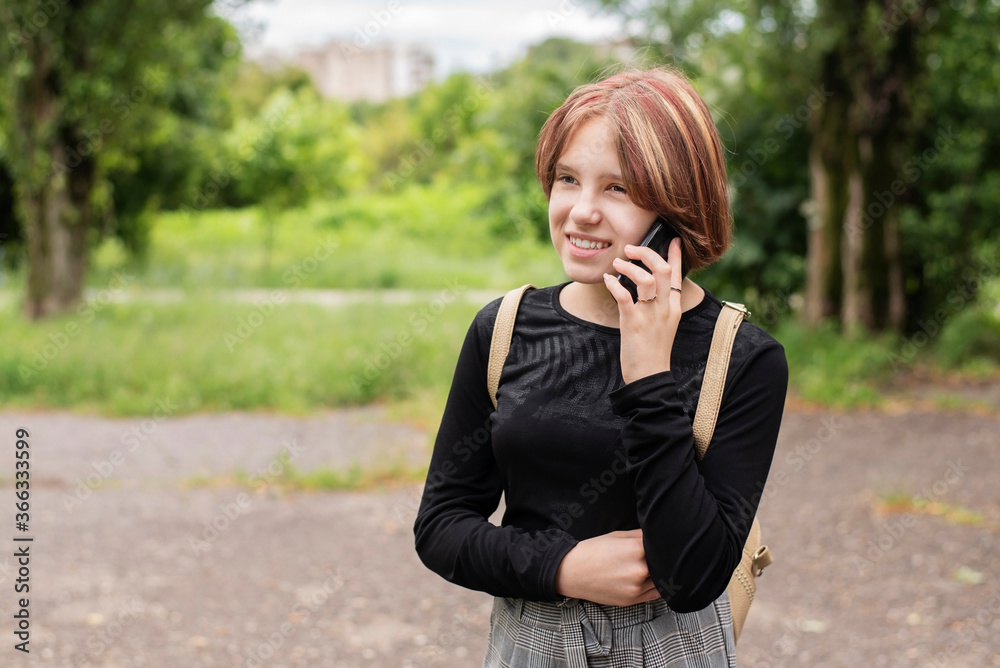 Beautiful teenage girl talking on the phone with a new girlfriend and smiling, the girl is happy to befriend a new faithful girlfriend and she has someone to talk to Beautiful teenage girl talking on the phone with a new girlfriend and smiling, the girl is happy to befriend a new faithful girlfriend and she has someone to talk to