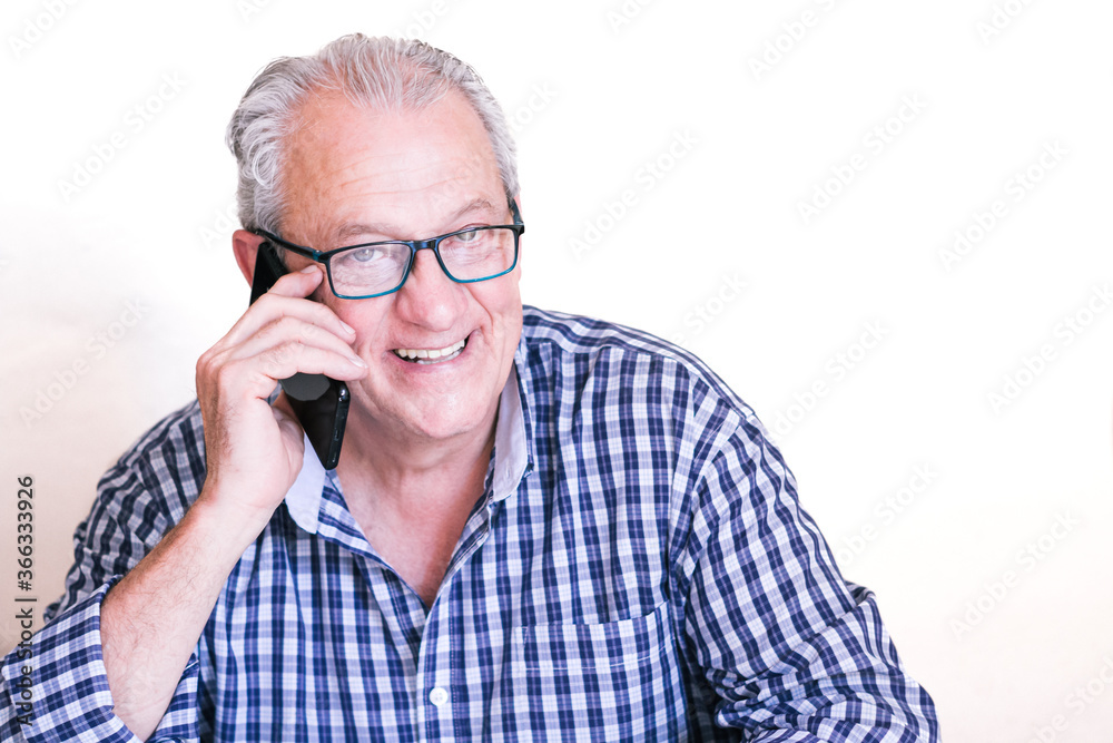 Handsome gray-haired man smiling as he makes a phone call. Handsome gray-haired man smiling as he makes a phone call.
